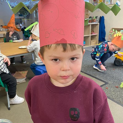 Boy at nursery wearing a paper crown