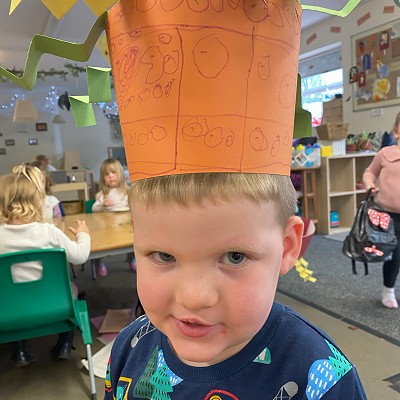 Boy at nursery wearing a paper crown