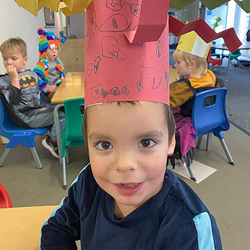 Boy at nursery wearing a paper crown