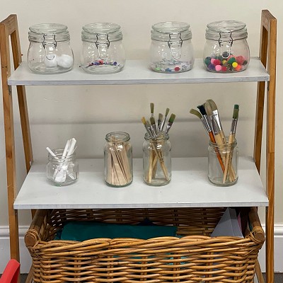 Jars on a shelf containing craft supplies