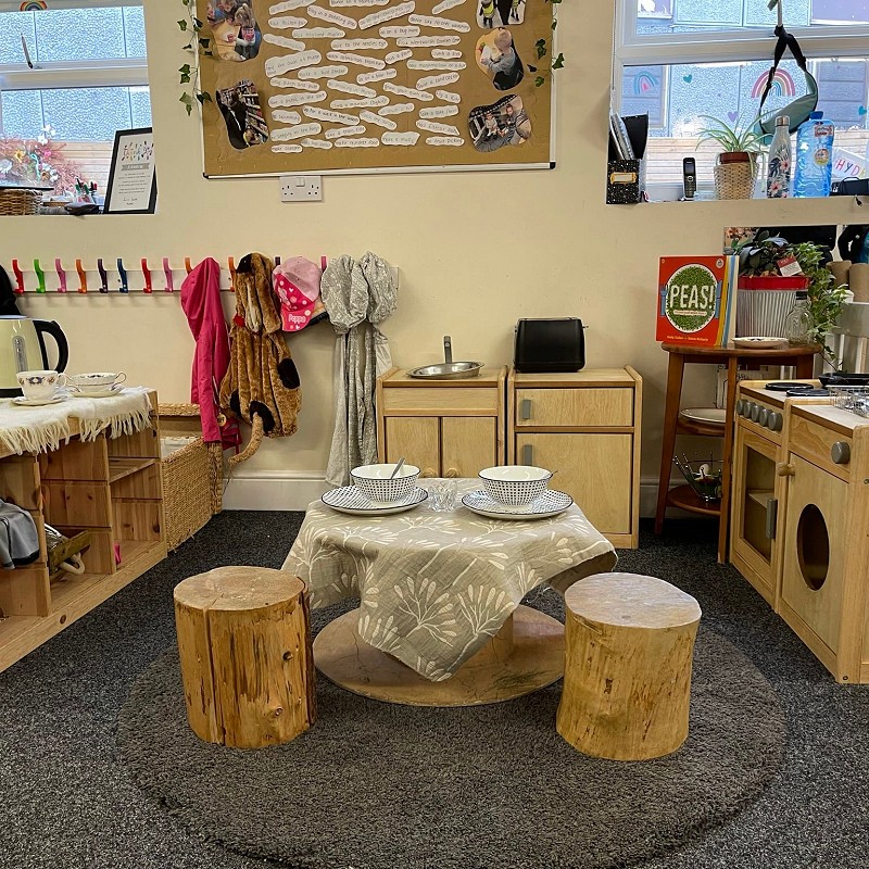 Wooden table and chairs with a tea set in the child’s play room