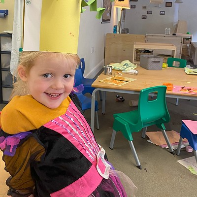 Child at nursery wearing a paper crown