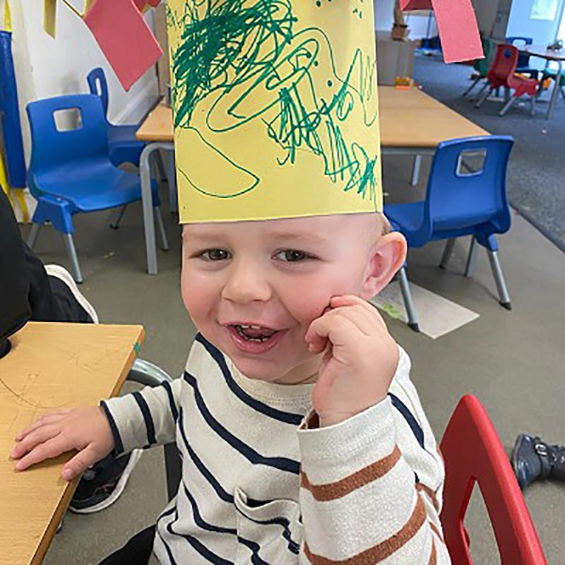 Boy at nursery wearing a paper crown