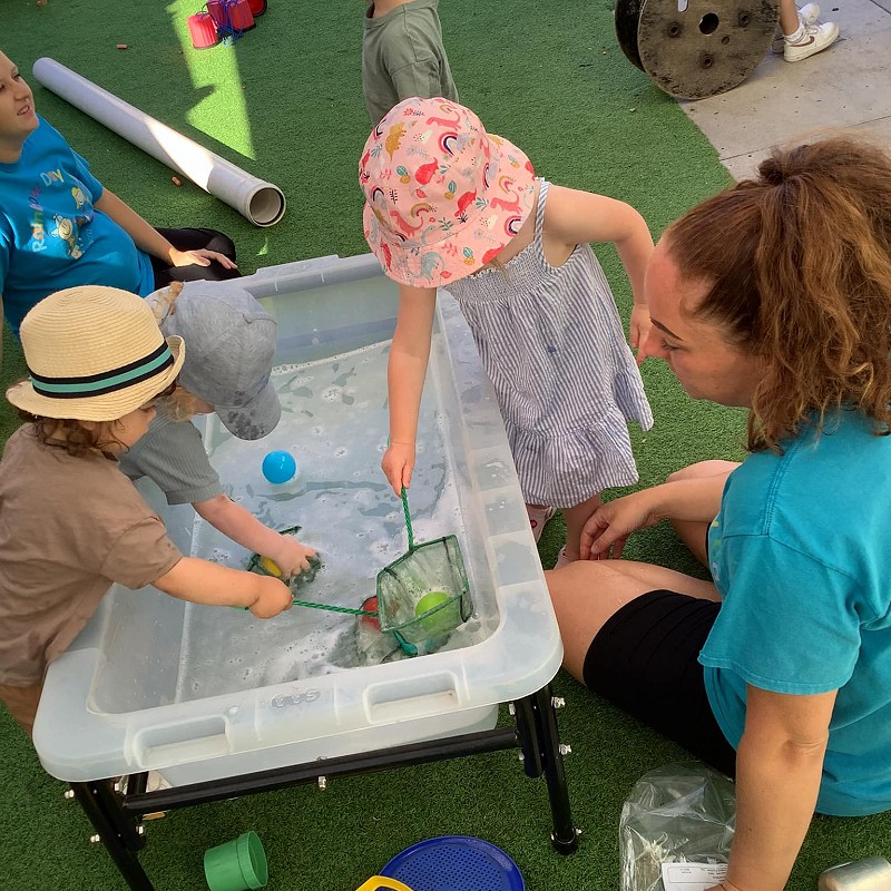 Supervised children playing in water at the nursery